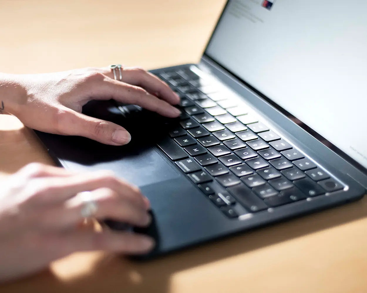 Hände tippen auf Laptop-Tastatur bei Tageslicht, Galerie Position 1, nachhaltige Herstellung, Schweizer Aromatherapie.