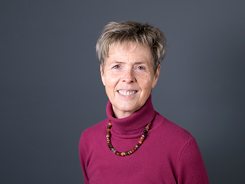 Porträt einer lächelnden Frau mit kurzem Haar vor grauem Hintergrund, Galerie Position 1, Schweizer Aromatherapie und Naturkosmetik