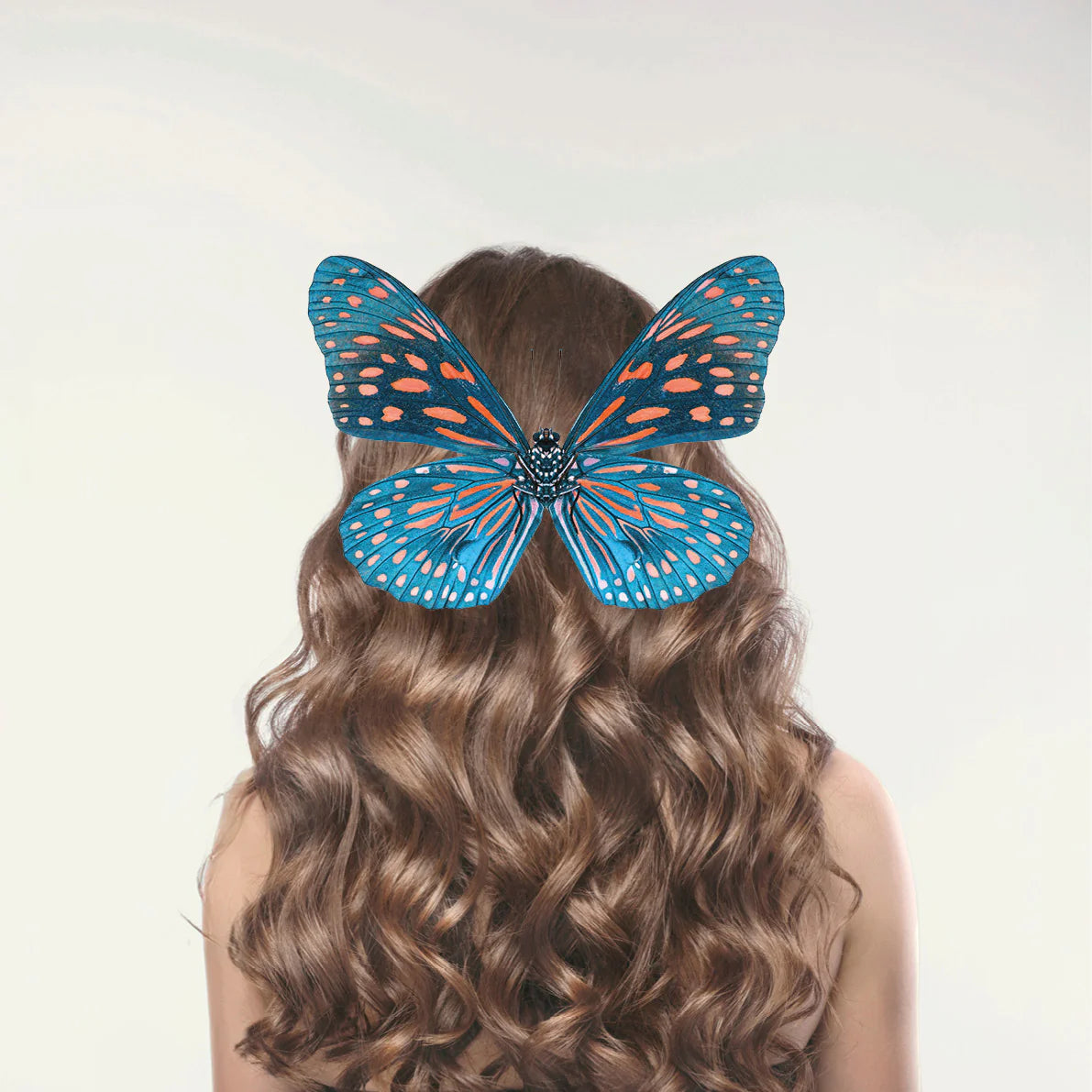 Frau mit langen lockigen Haaren und großem blauen Schmetterling auf dem Hinterkopf, Galerie Position 1, Schweizer Aromatherapie
