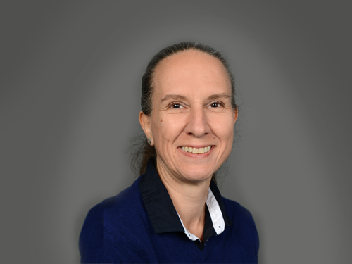 Porträt einer lächelnden Frau mit zurückgebundenem Haar vor grauem Hintergrund, Galerie Position 1, Schweizer Aromatherapie