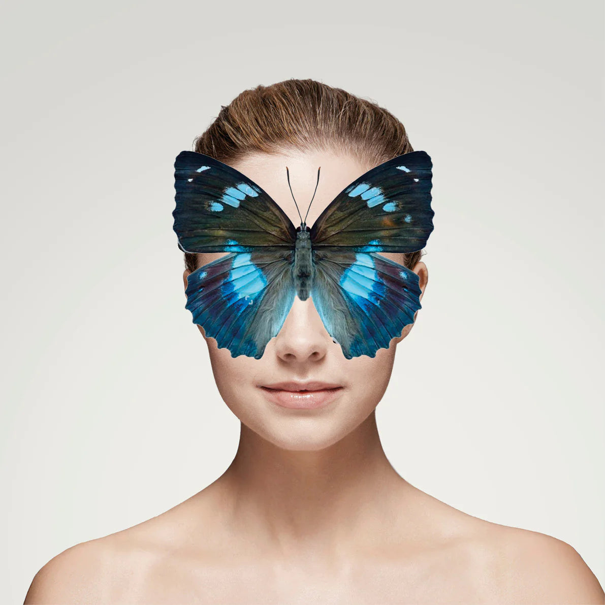 Frau mit zurückgebundenem Haar, großer blauer Schmetterling verdeckt Augen, Galerie Position 1, Schweizer Aromatherapie und zertifizierte Naturkosmetik