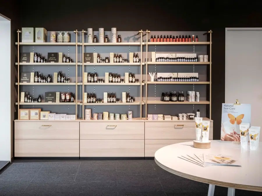 Hell eingerichteter Verkaufsraum mit Holzregalen und Pflegeölen, Galerie Position 1, Schweizer Aromatherapie, vegane Rezepturen