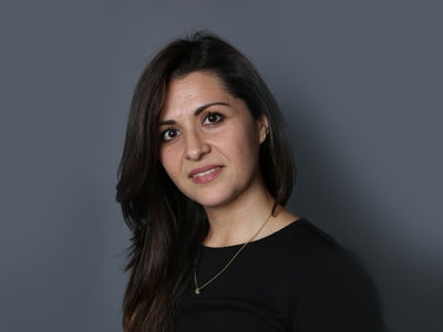 Frau mit dunkelbraunen Haaren vor grauem Hintergrund, Galerie Position 1, Schweizer Aromatherapie, vegane Rezepturen, zertifizierte Naturkosmetik