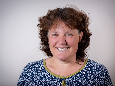 Porträt lächelnde Frau mit lockigem Haar vor neutralem Hintergrund, Galerie Position 1, Schweizer Aromatherapie